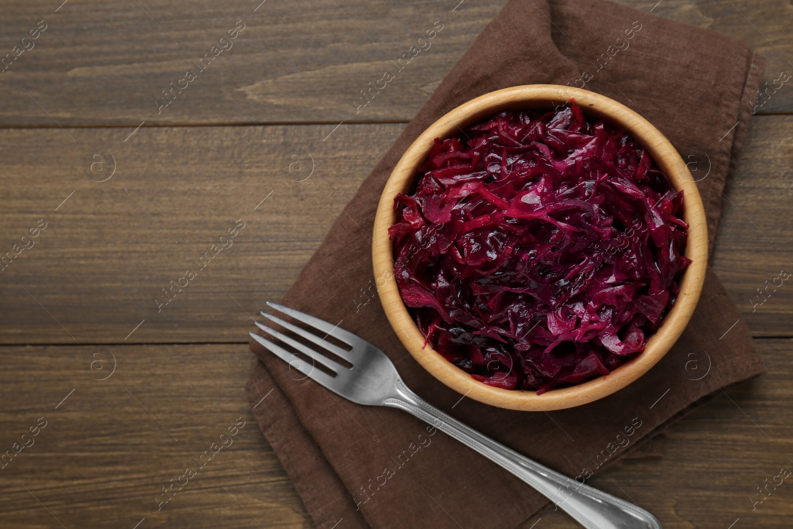 Photo of Tasty red cabbage sauerkraut on wooden table, top view. Space for text