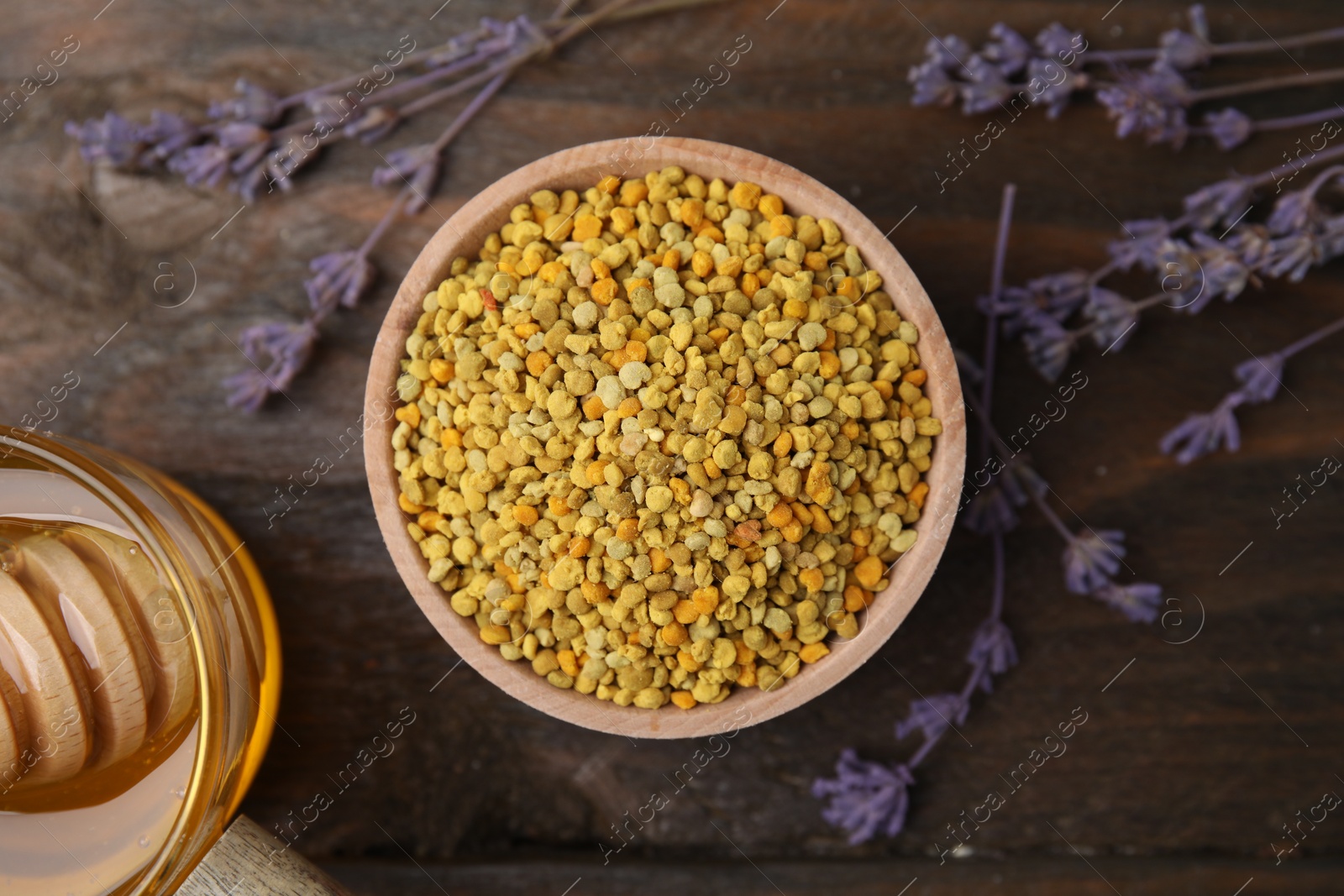 Photo of Fresh bee pollen granules and lavender on wooden table, flat lay