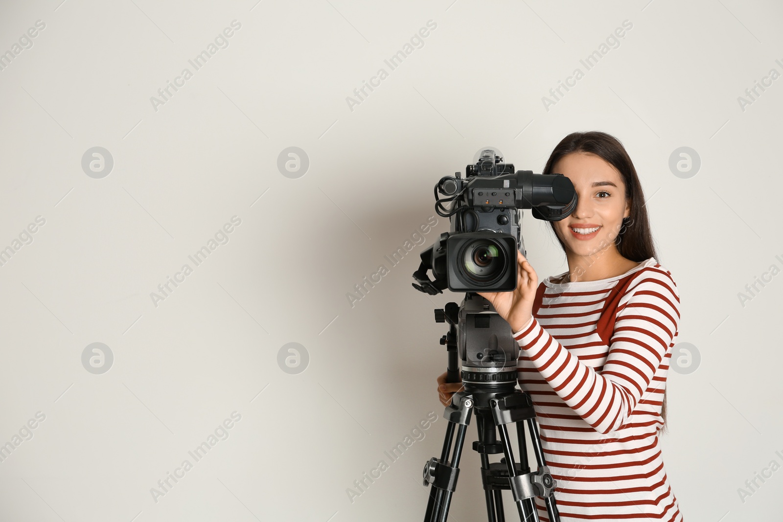 Photo of Operator with professional video camera on white background, space for text