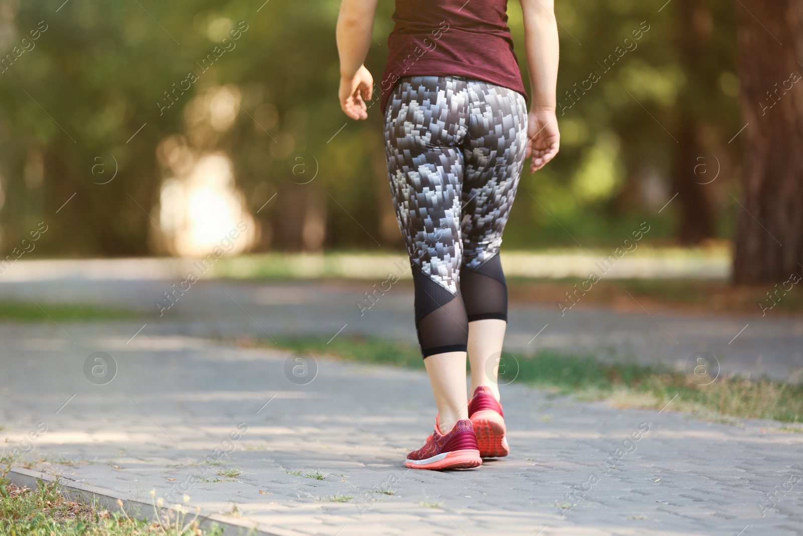 Photo of Young woman running in park on sunny day