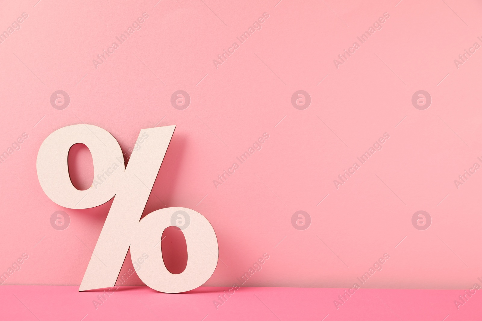 Photo of White wooden percent sign on pink background. Space for text