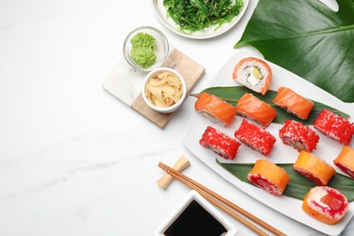 Photo of Flat lay composition with delicious sushi rolls on white marble table. Space for text