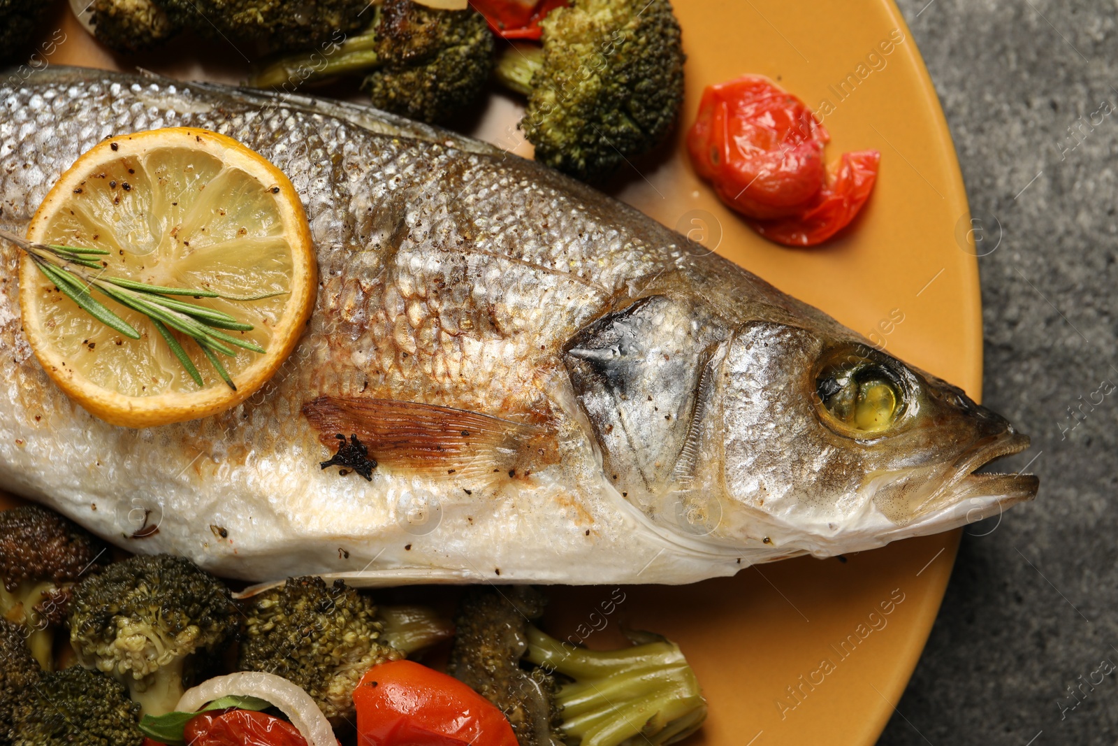 Photo of Delicious baked fish and vegetables on grey background, top view