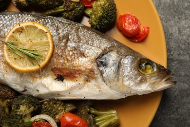 Photo of Delicious baked fish and vegetables on grey background, top view