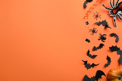 Photo of Halloween decor elements on orange background, flat lay. Space for text