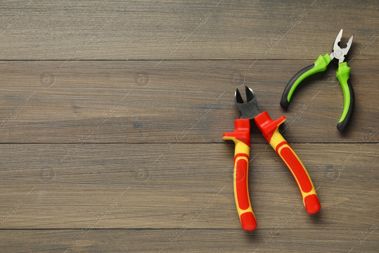 Photo of Pliers on wooden table, flat lay. Space for text