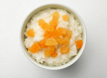 Delicious rice pudding with dried apricots on white table, top view