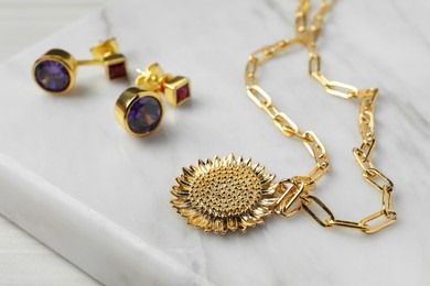 Necklace and earrings on white table, closeup