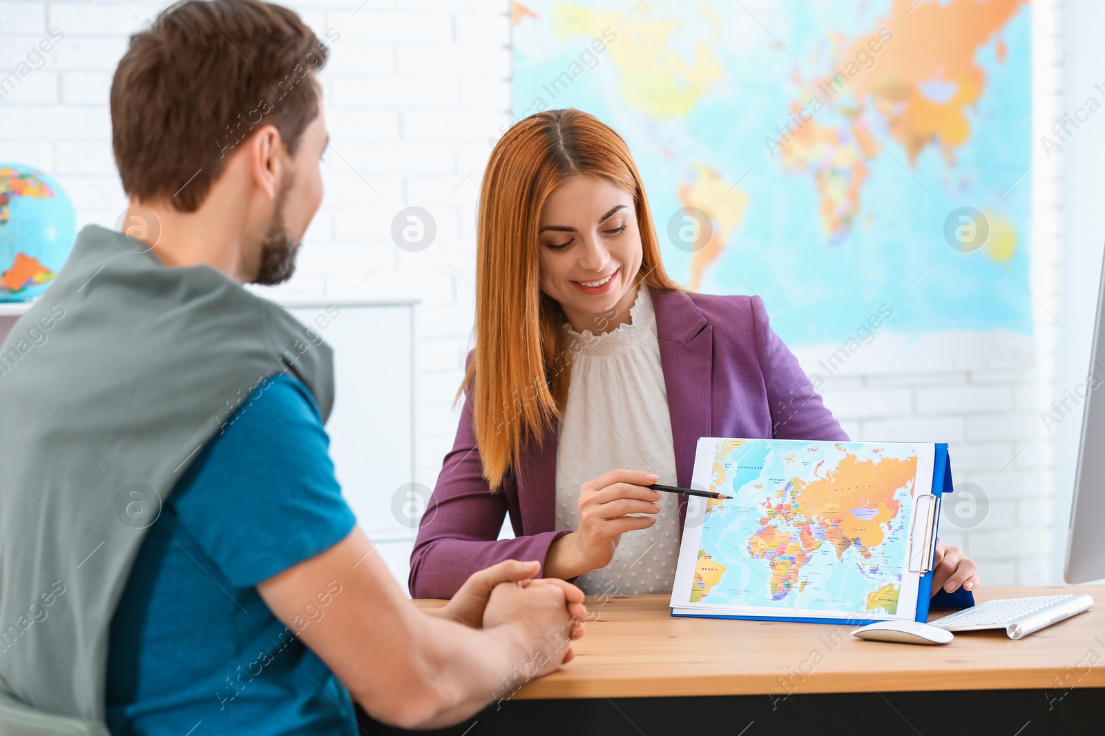 Photo of Female manager consulting client in travel agency