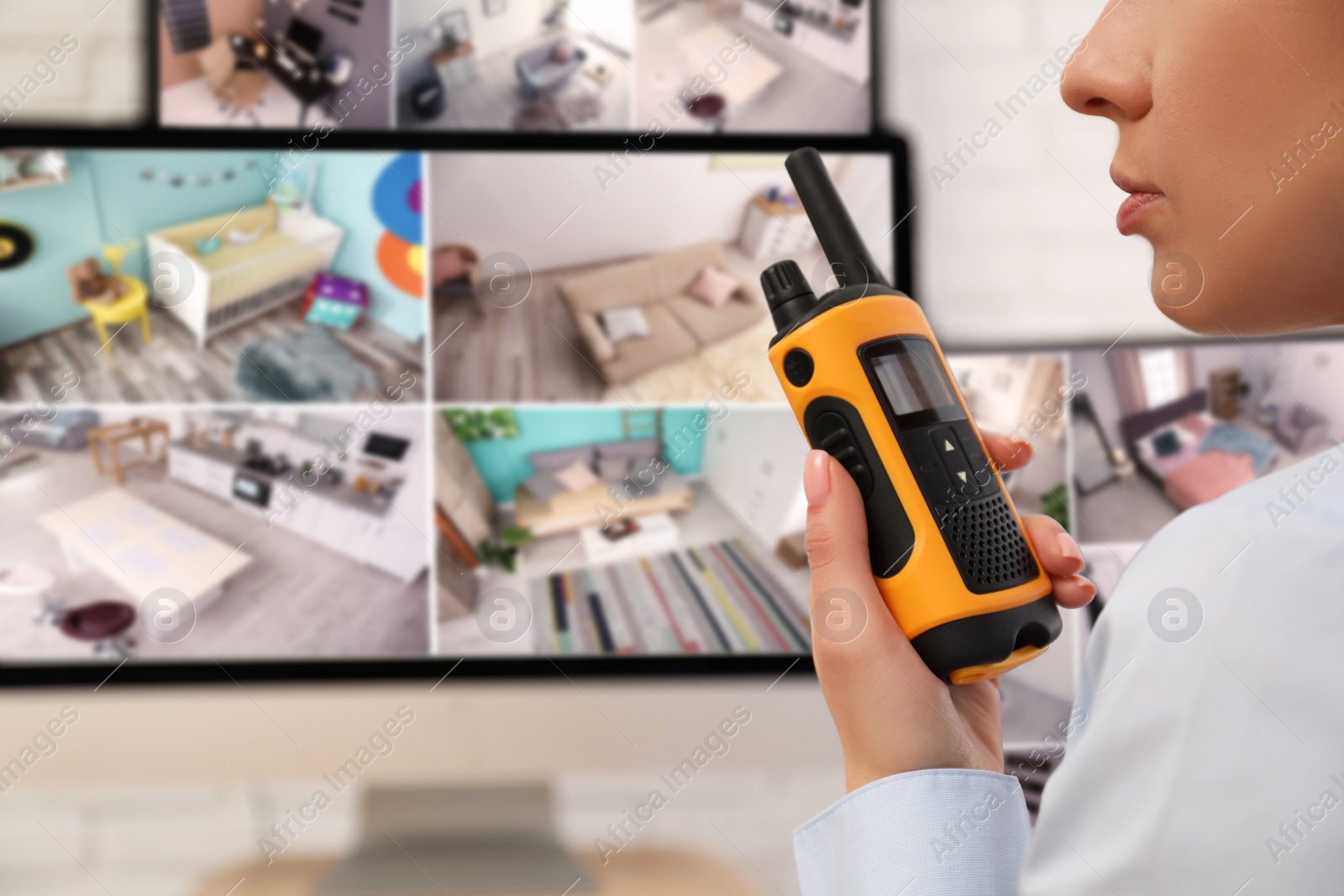 Photo of Female security guard with portable transmitter near monitors at workplace, closeup