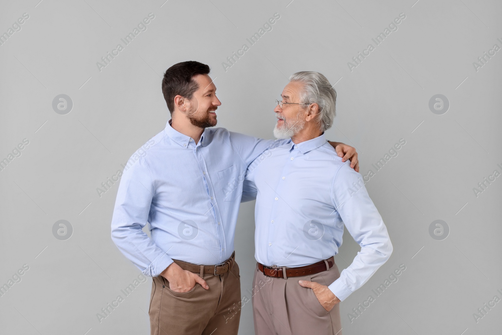Photo of Happy son and his dad on gray background