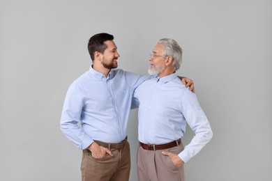 Photo of Happy son and his dad on gray background