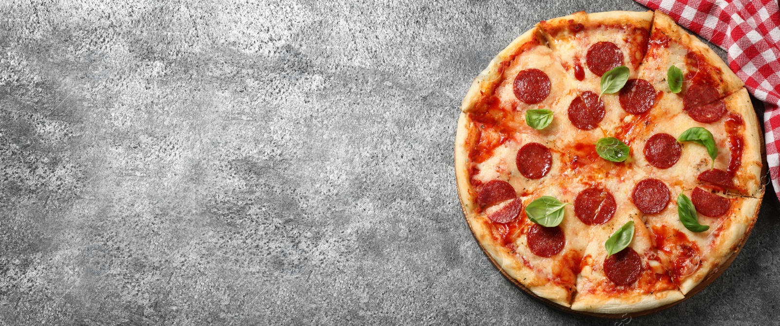 Image of Top view of hot delicious pizza on grey table, space for text. Banner design 