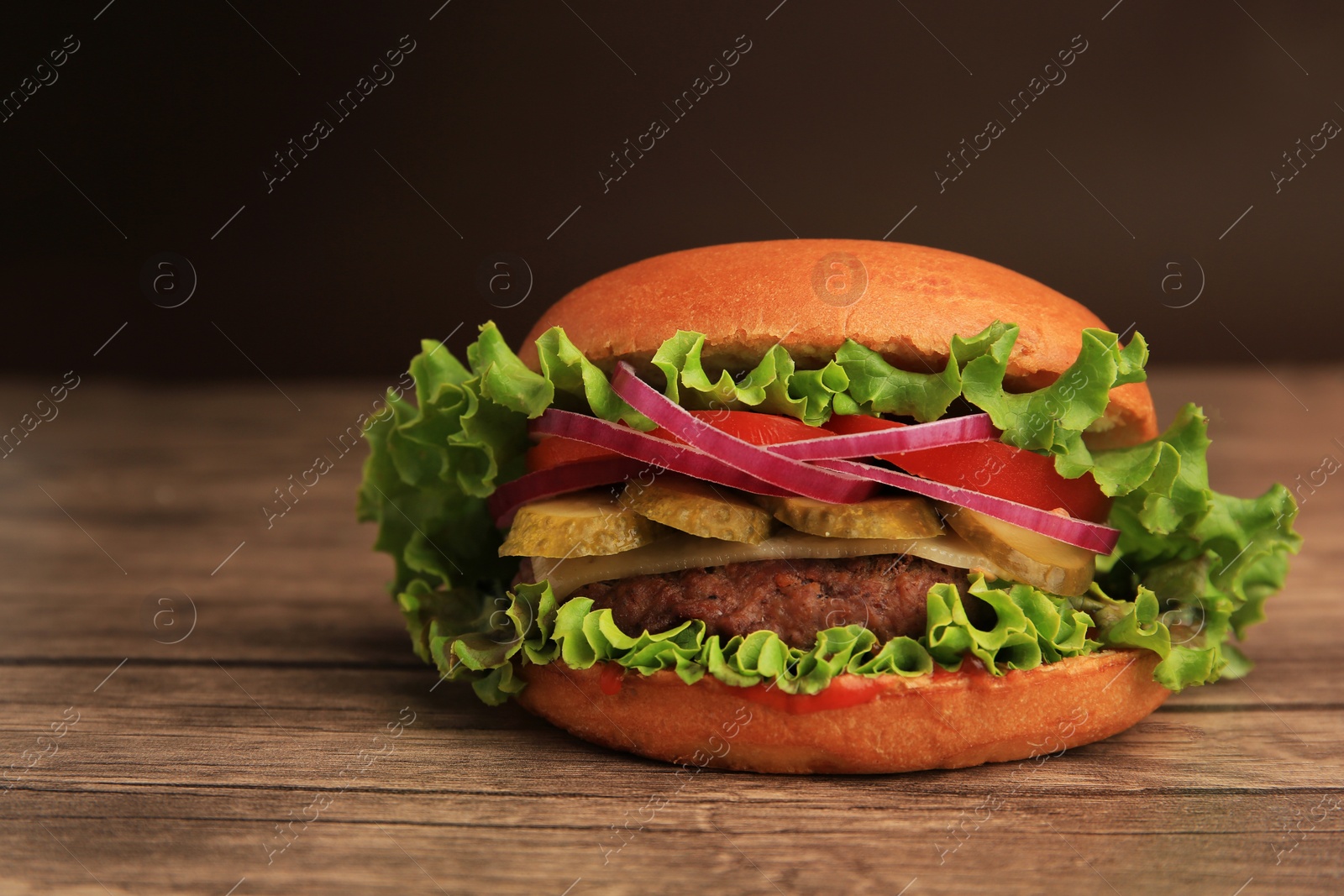 Photo of One tasty burger on wooden table, closeup. Space for text