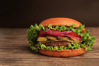 Photo of One tasty burger on wooden table, closeup. Space for text