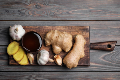 Photo of Fresh garlic and other natural cold remedies on light grey wooden table, top view