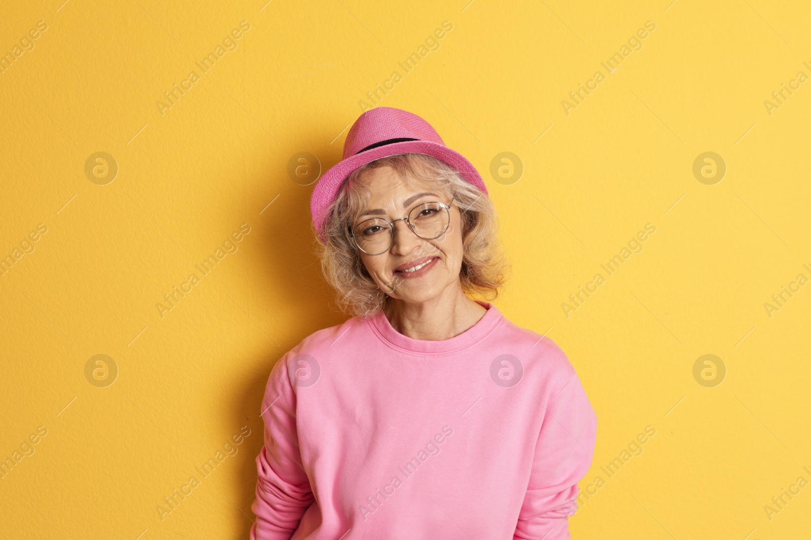 Photo of Portrait of mature woman in hipster outfit on color background