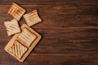 Tasty toasted bread on wooden background, top view