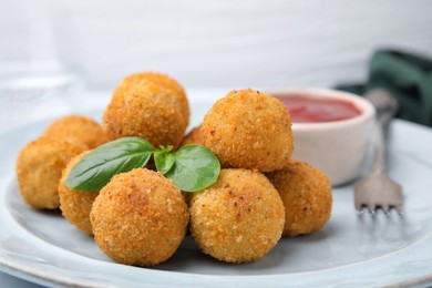 Photo of Delicious fried tofu balls with basil and sauce on table, closeup