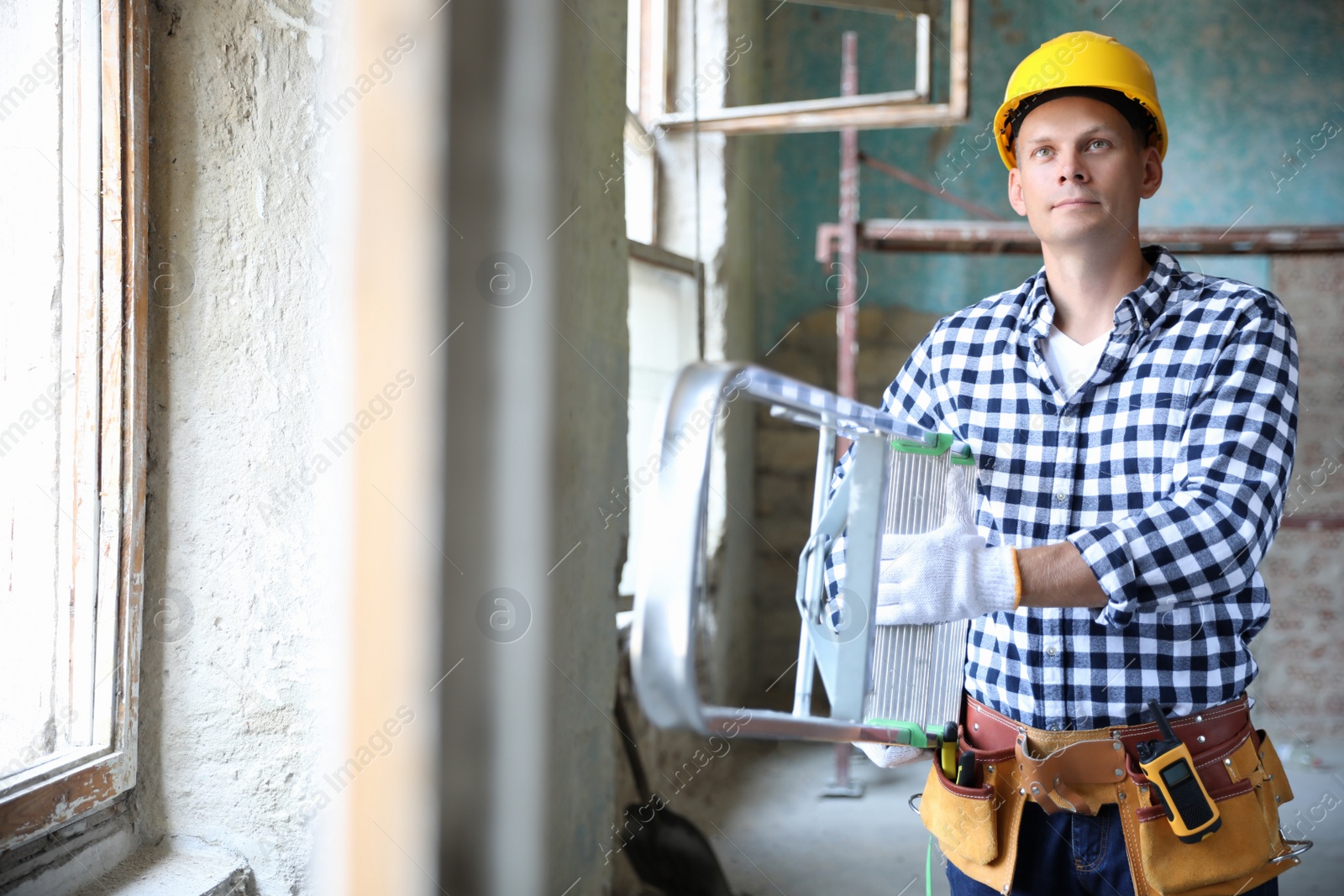 Photo of Professional constructor with ladder in old building