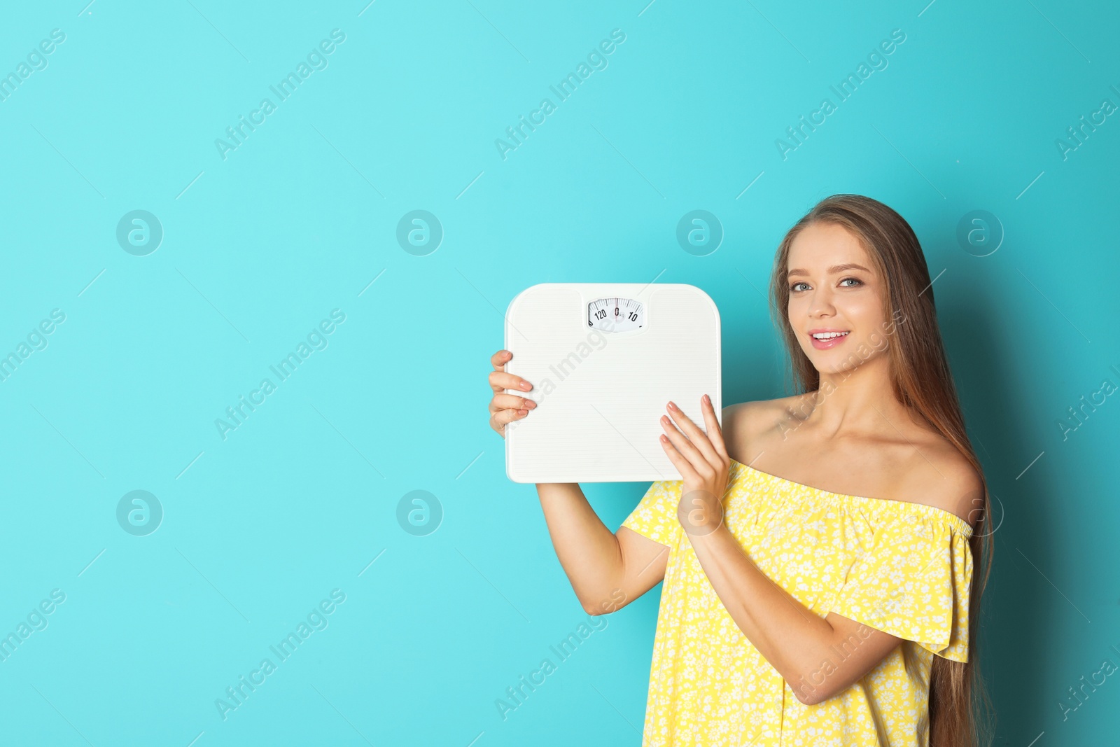 Photo of Beautiful young woman with scales on color background. Healthy diet