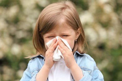 Photo of Little girl suffering from seasonal spring allergy outdoors