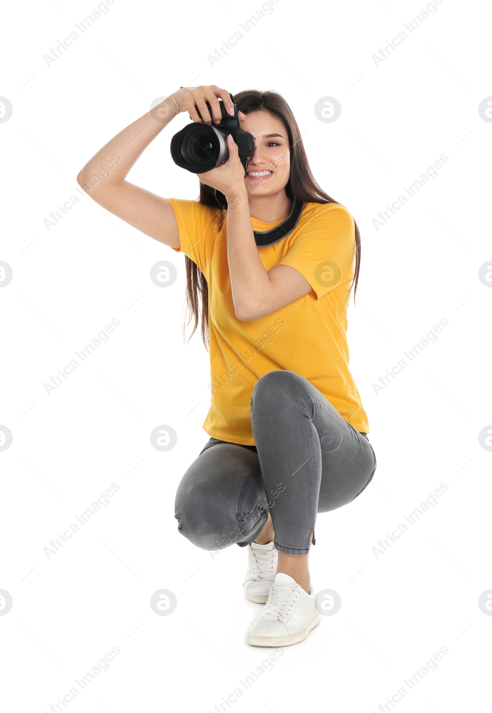 Photo of Young female photographer with camera on white background