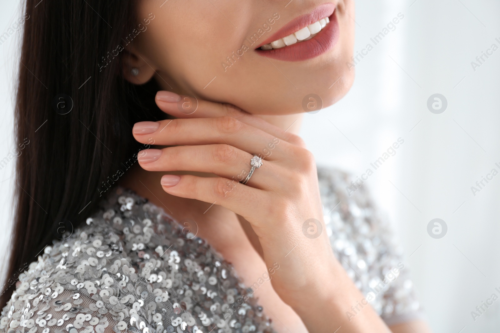 Photo of Young woman wearing beautiful engagement ring, closeup