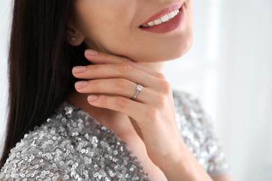 Photo of Young woman wearing beautiful engagement ring, closeup