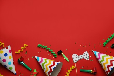 Photo of Flat lay composition with party items on red background, space for text