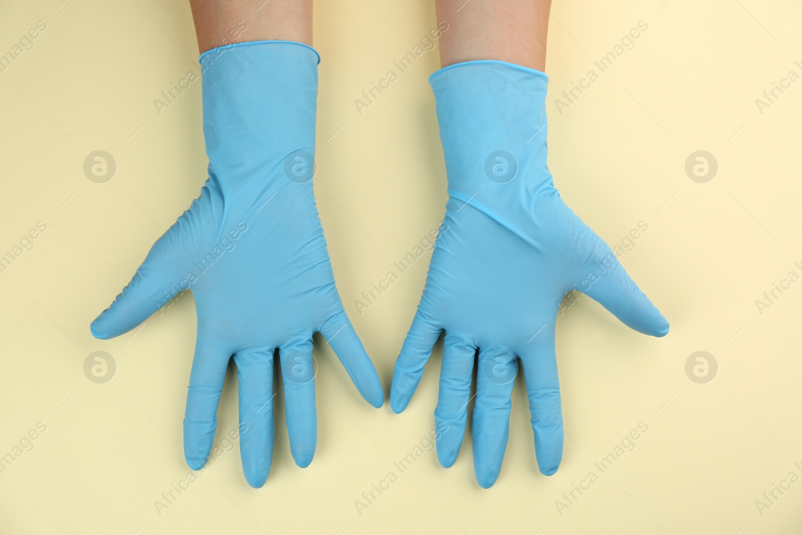 Photo of Person in medical gloves on beige background, top view