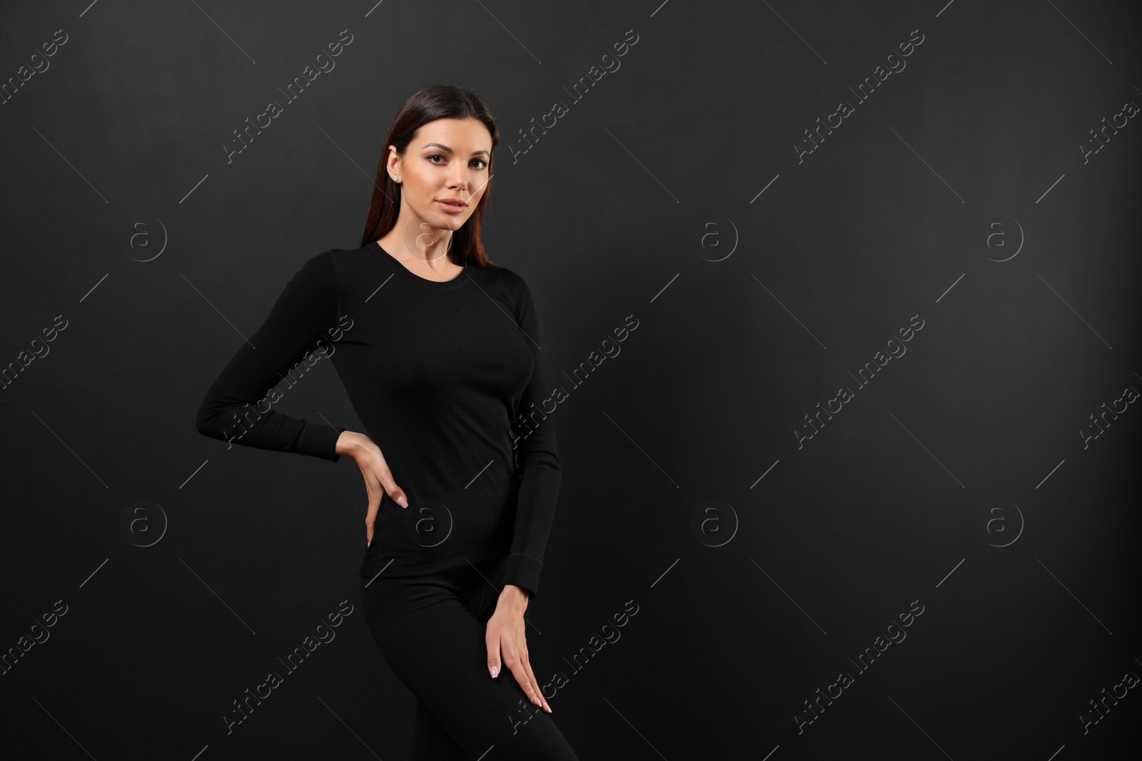 Photo of Woman wearing thermal underwear on black background. Space for text