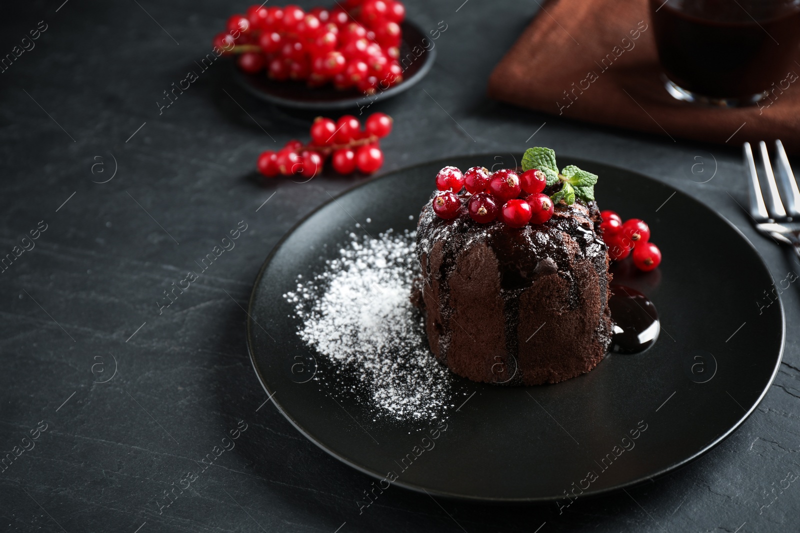 Photo of Delicious warm chocolate lava cake with mint and berries on dark grey table