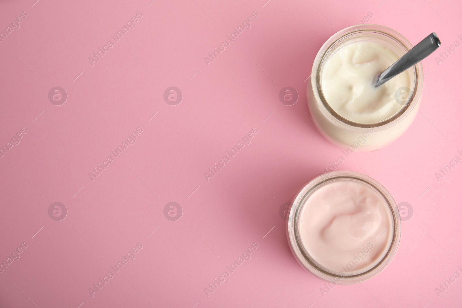 Photo of Tasty organic yogurt on pink background, flat lay. Space for text