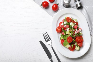 Photo of Delicious salad with watermelon, vegetables and feta cheese served on white wooden table, flat lay. Space for text