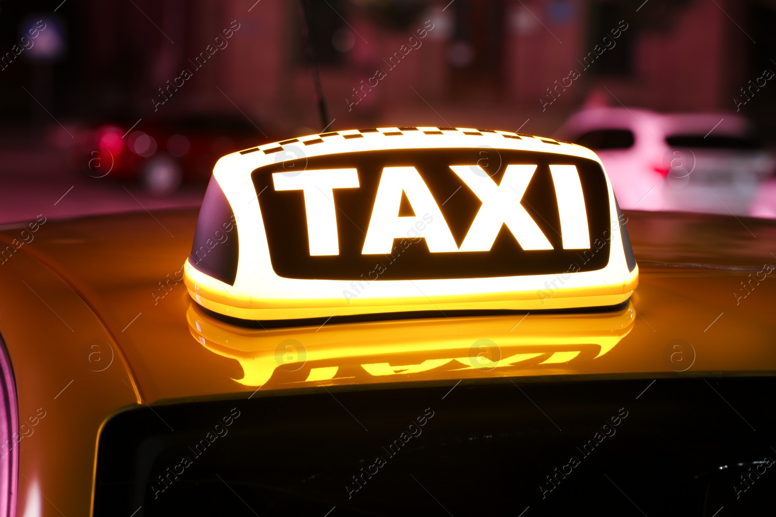 Photo of Taxi car with yellow sign outdoors at night, closeup