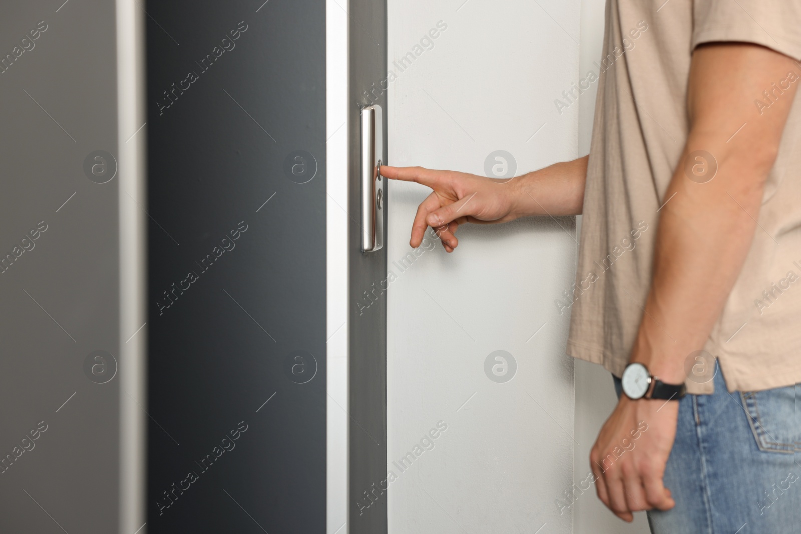 Photo of Man pressing elevator call button, closeup view