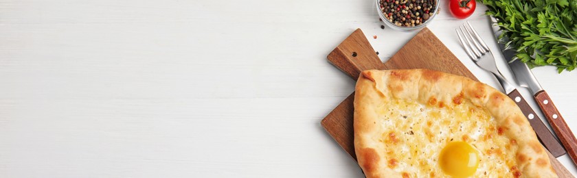 Image of Delicious Adjarian khachapuri served on white wooden table, flat lay. Banner design with space for text