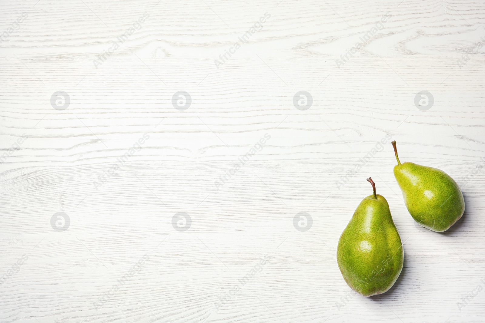 Photo of Ripe pears on wooden background, top view. Space for text