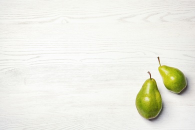 Ripe pears on wooden background, top view. Space for text