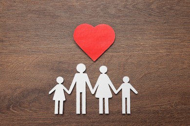 Paper family cutout and red heart on wooden background, flat lay. Insurance concept