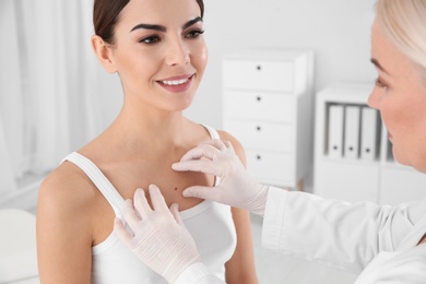 Photo of Dermatologist examining young patient's birthmark in clinic