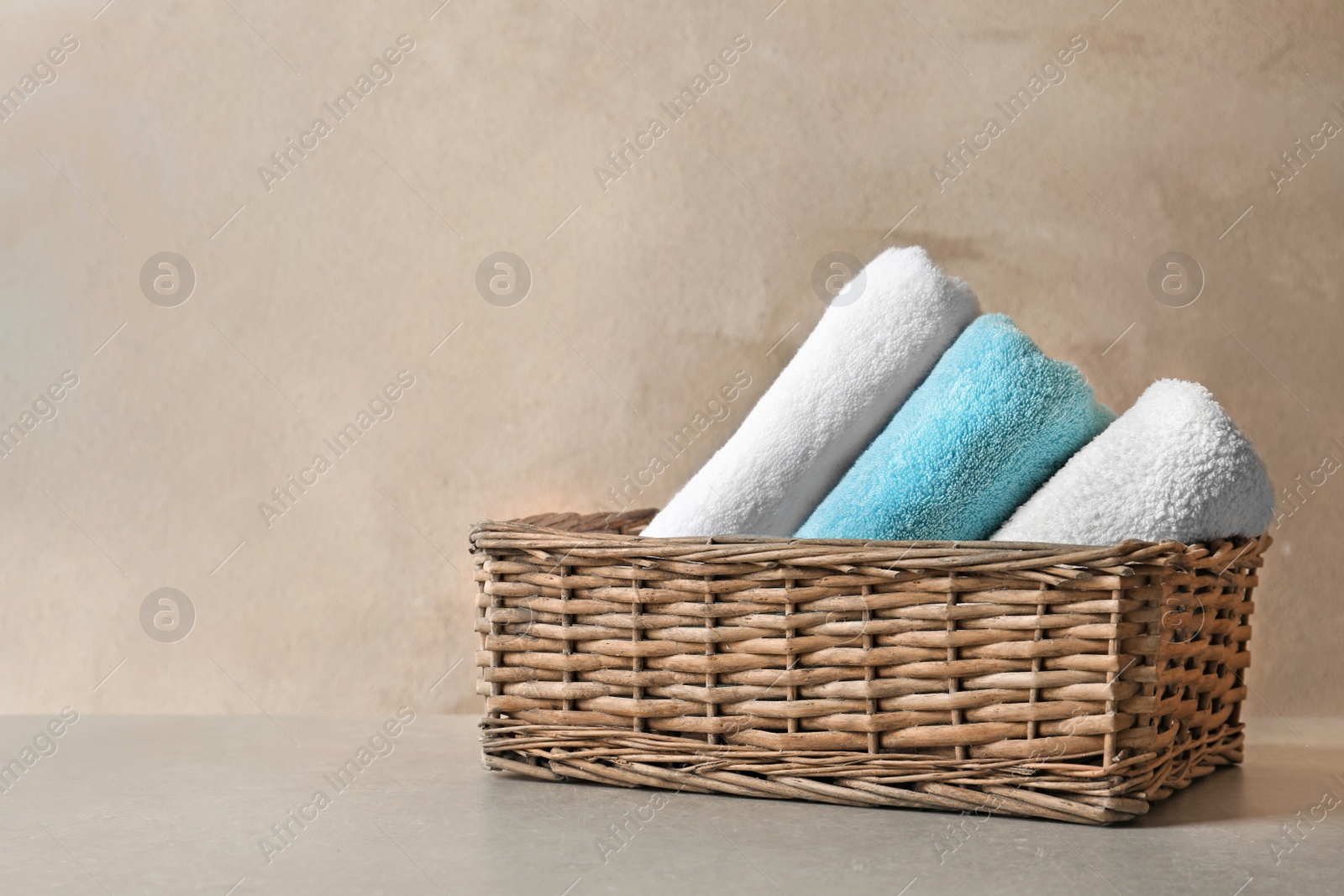 Photo of Basket with clean towels on table