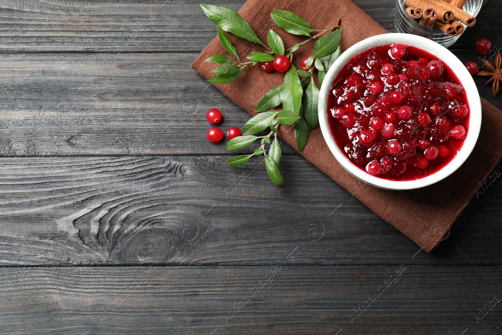 Photo of Flat lay composition with cranberry sauce on grey wooden table, space for text