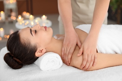 Photo of Young woman receiving massage in spa salon