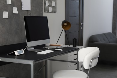 Photo of Stylish room interior with comfortable workplace near grey wall