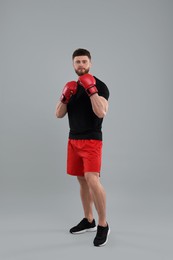 Photo of Man in boxing gloves on grey background