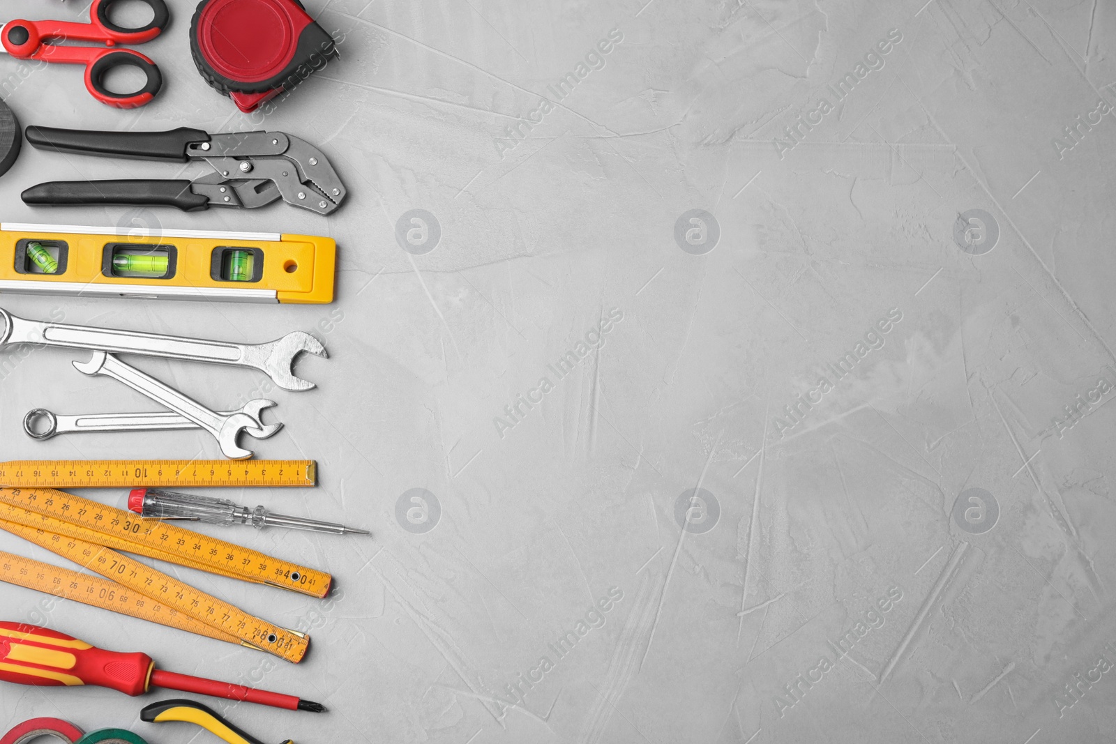 Photo of Flat lay composition with construction tools on light grey background. Space for text