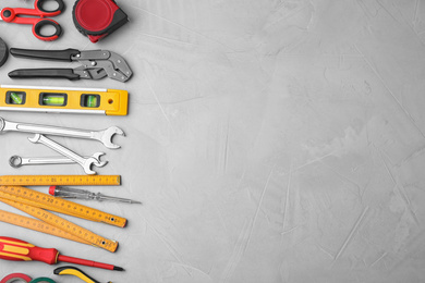 Flat lay composition with construction tools on light grey background. Space for text