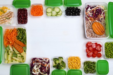 Frame of plastic containers with fresh food on white wooden table, flat lay. Space for text